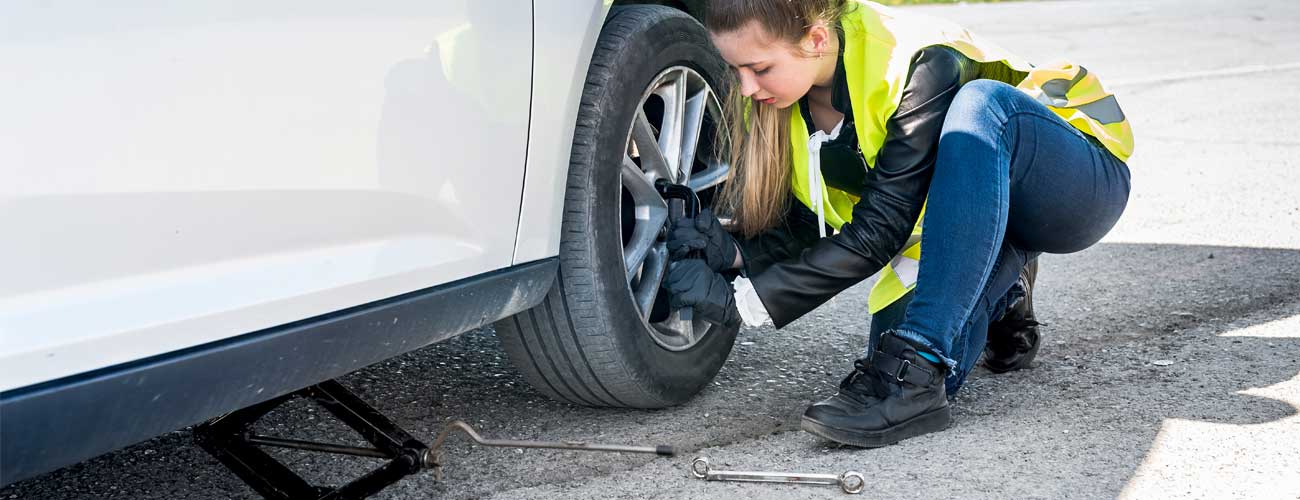 A Woman in Hi Vis changing a tyre